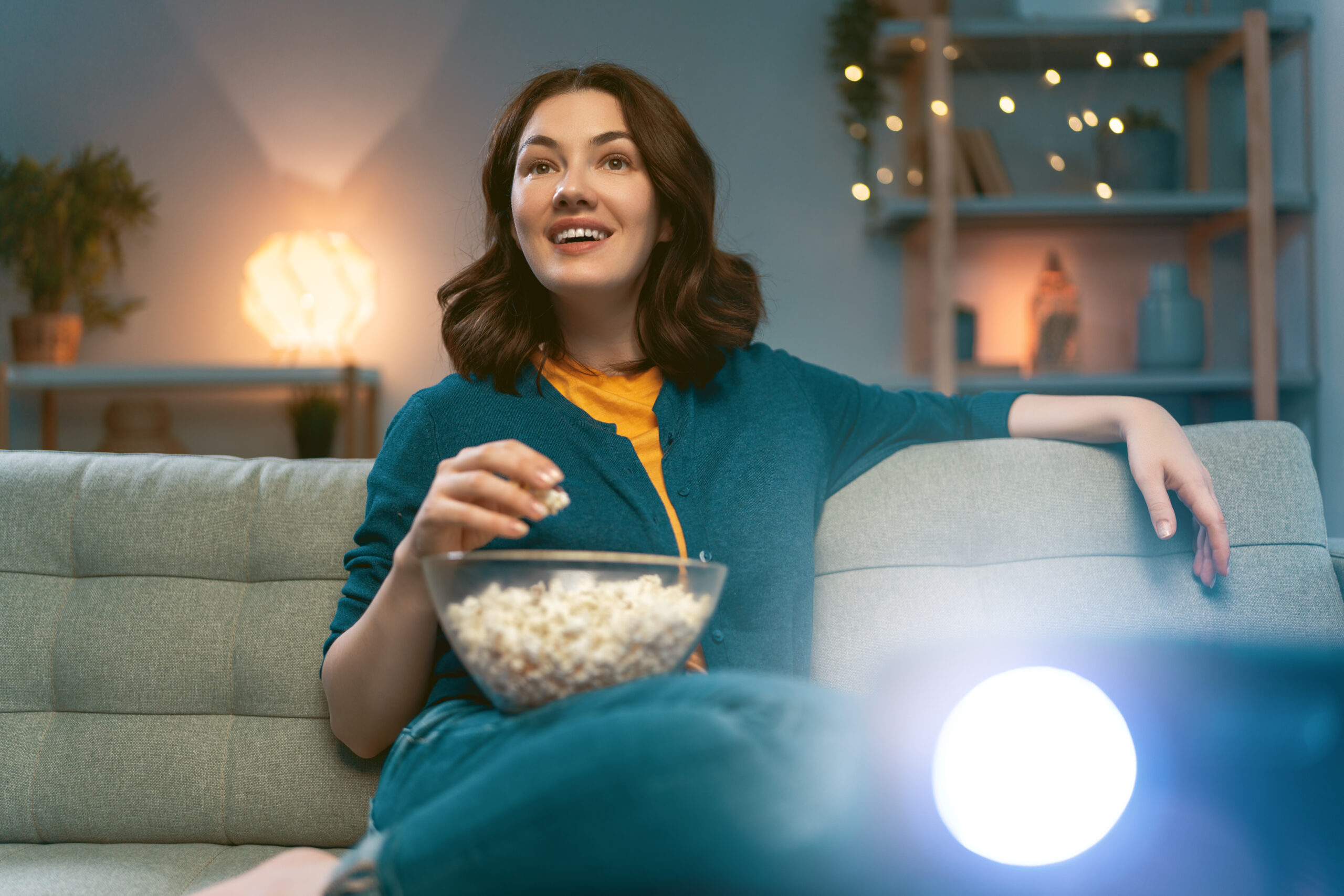 Nő kanapén relaxál otthoni internet kapcsolattal