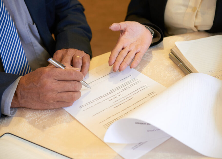 Senior Business People Signing Document Close-up image of business partners signing contract after successful meeting